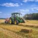 Trator em campo agrícola ao entardecer, com display digital no painel exibindo dados de operação.