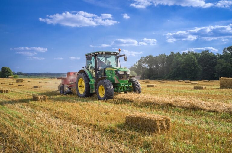 Trator em campo agrícola ao entardecer, com display digital no painel exibindo dados de operação.